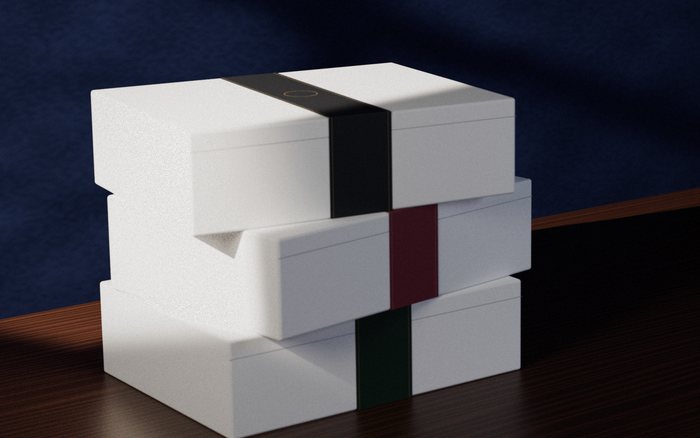 Three white Pactis boxes stacked, banded in charcoal, claret and forest green: the band is designed in your colours, with room for your mark