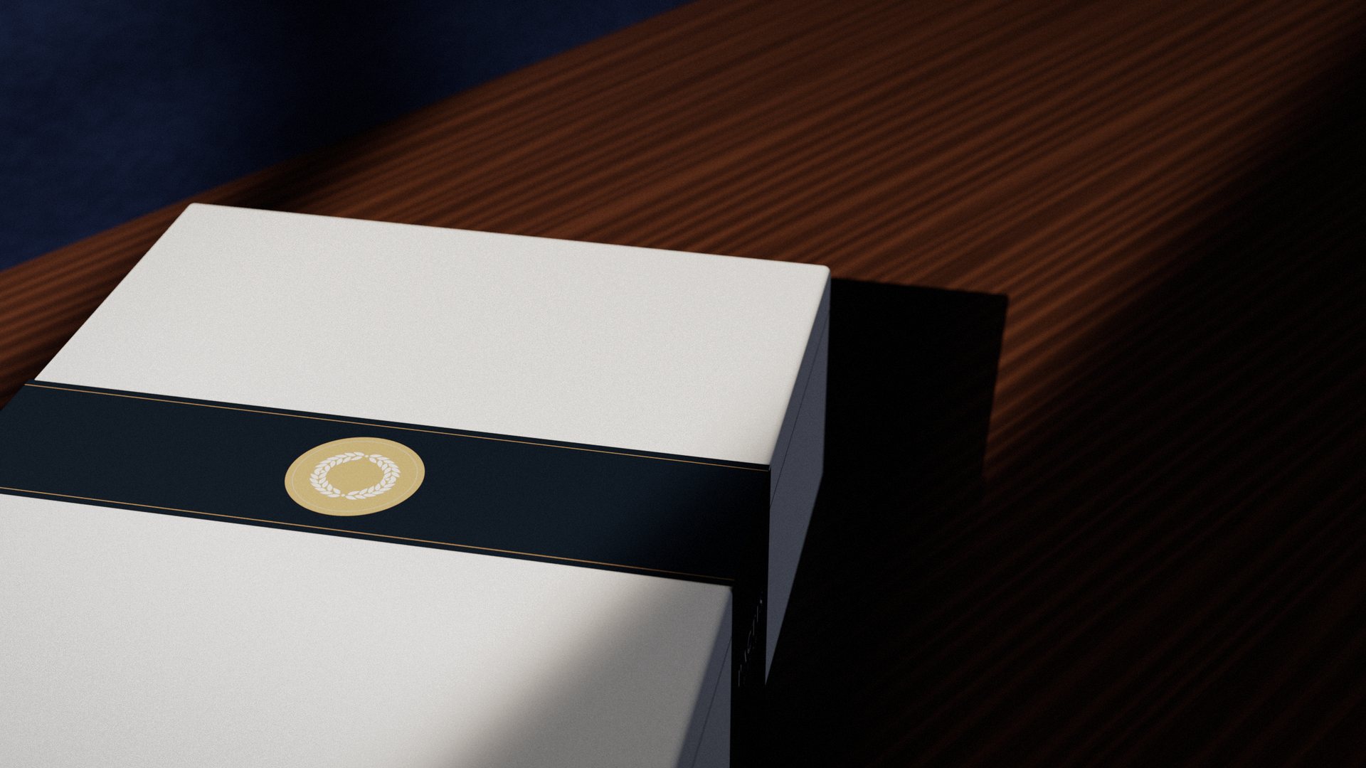 Close-up of the brass Pactis seal on the navy belly band across the lid of a white gift box